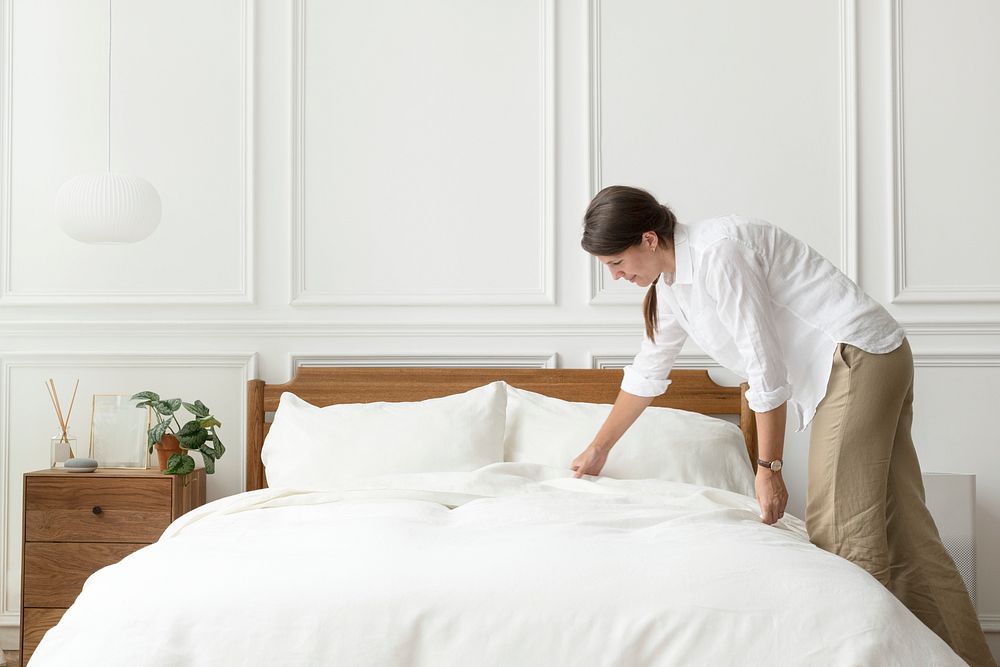 Woman making her bed, Scandinavian interior style
