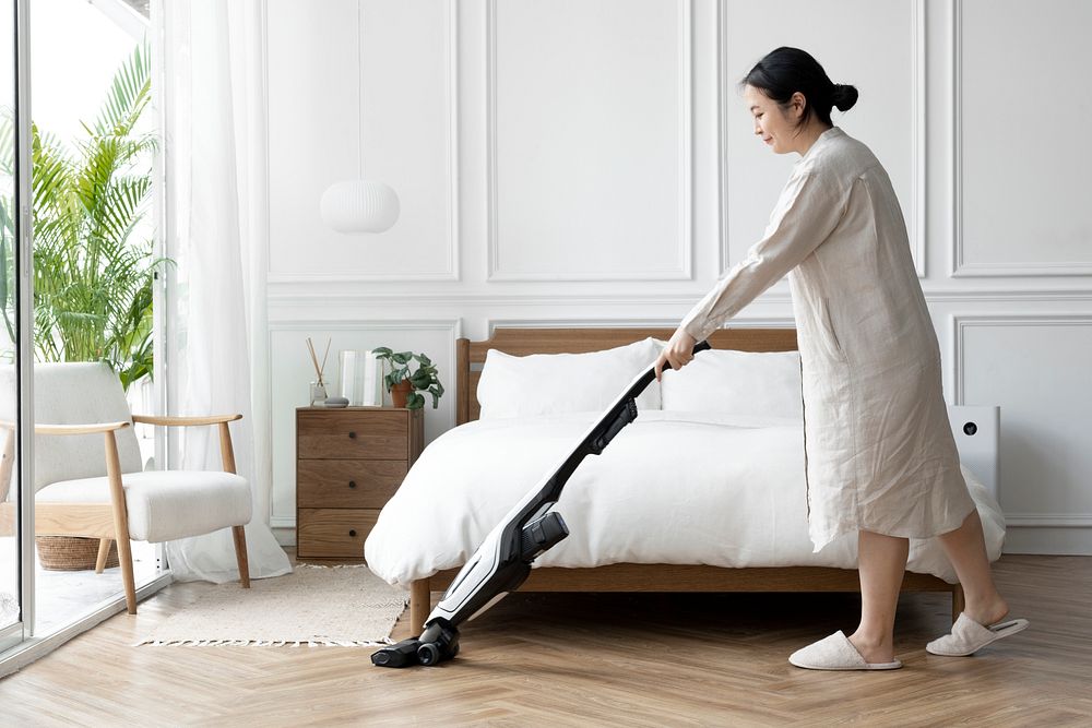 Japanese woman vacuuming her bedroom