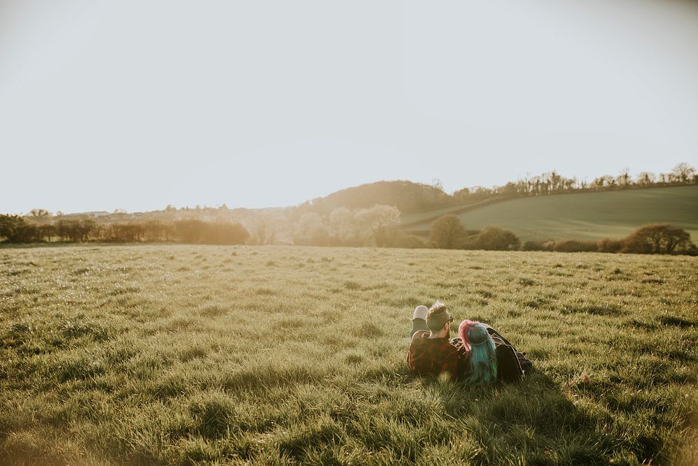 Couple laying down on a field  