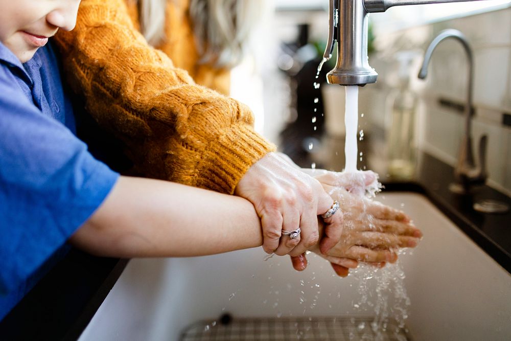 Boy washing his hands to lessen the chance of COVID-19