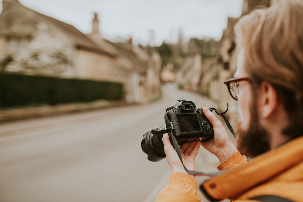 Photographer man viewing his photos on the camera