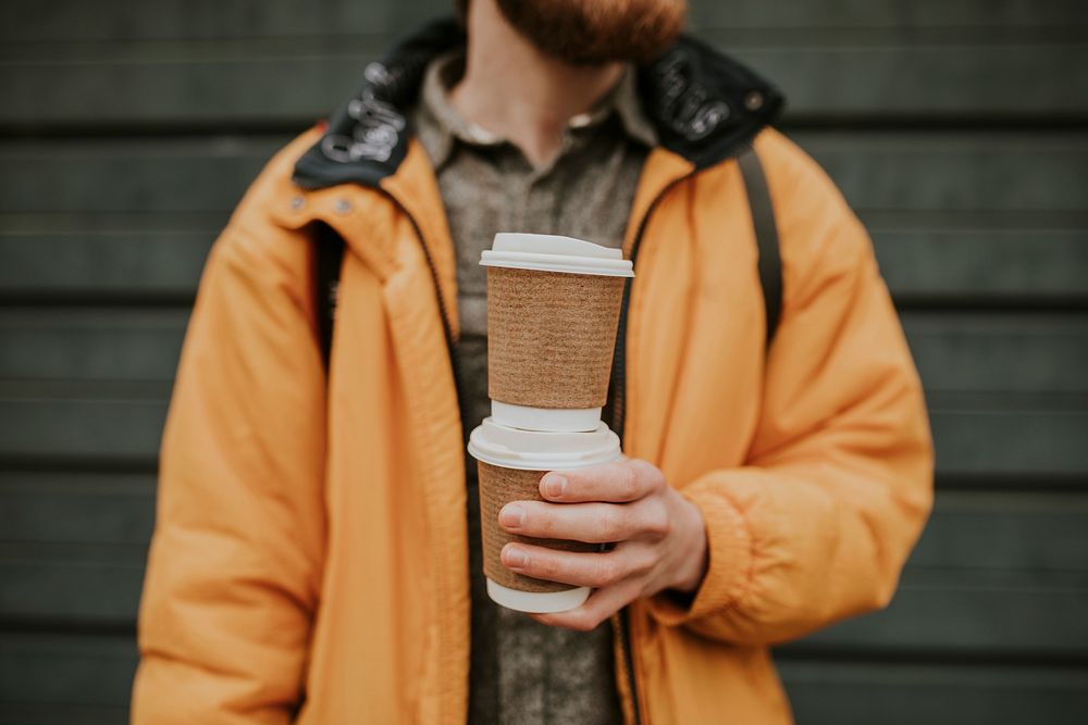 Tourist holding stacked coffee cups