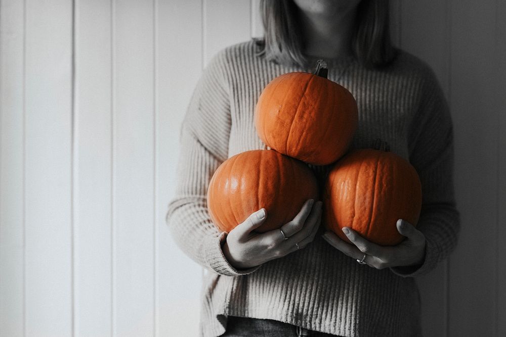 Woman holding Halloween pumpkins in a farmhouse monotone