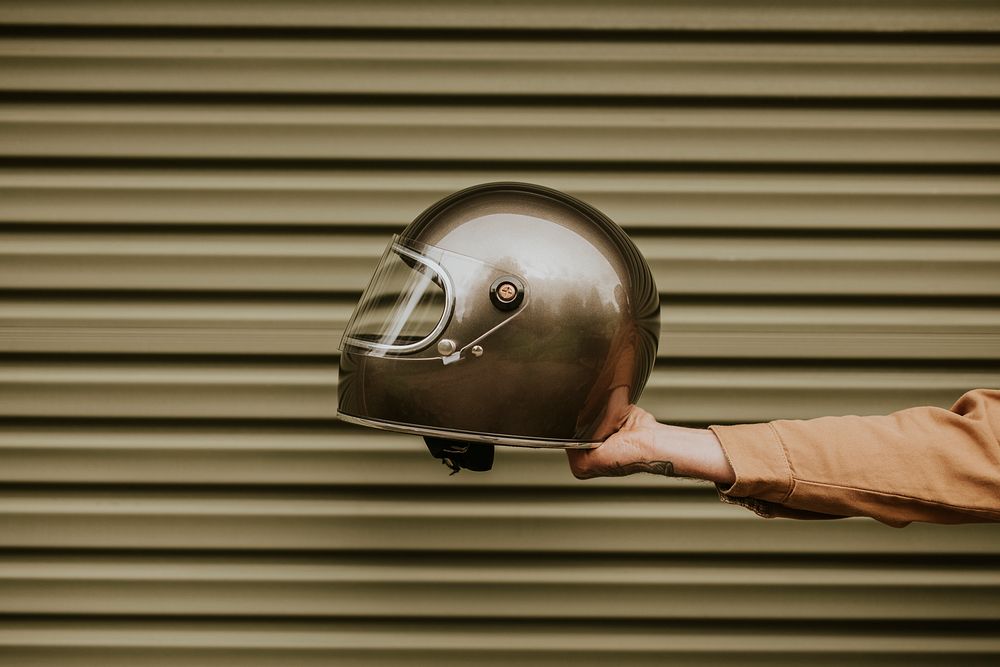 Tattoo hand holding a black helmet