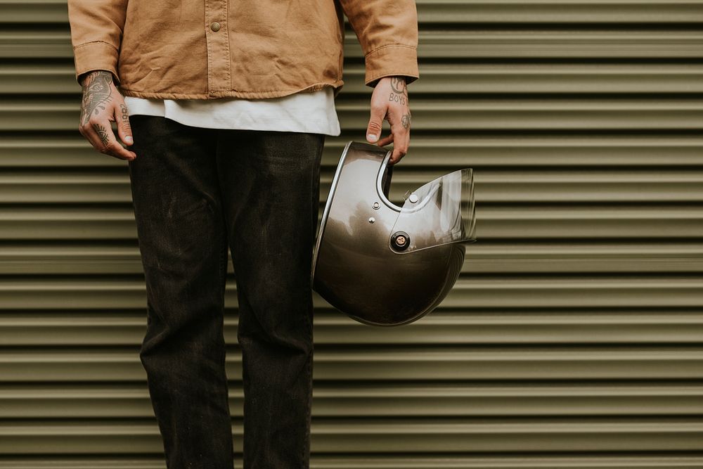 Tattoo hand holding a black helmet