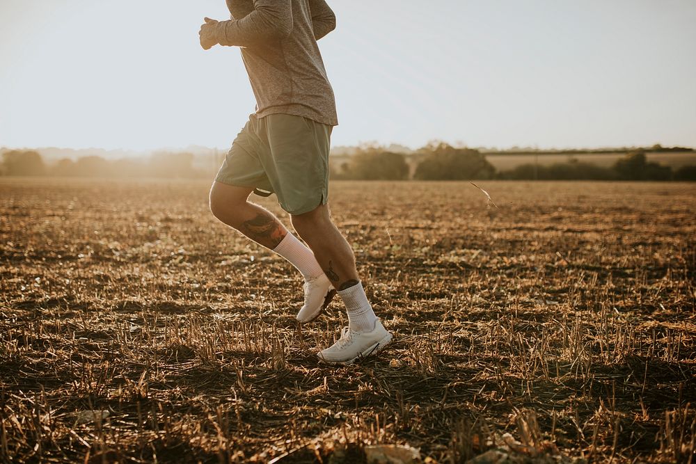 Active man in sportswear running in the countryside