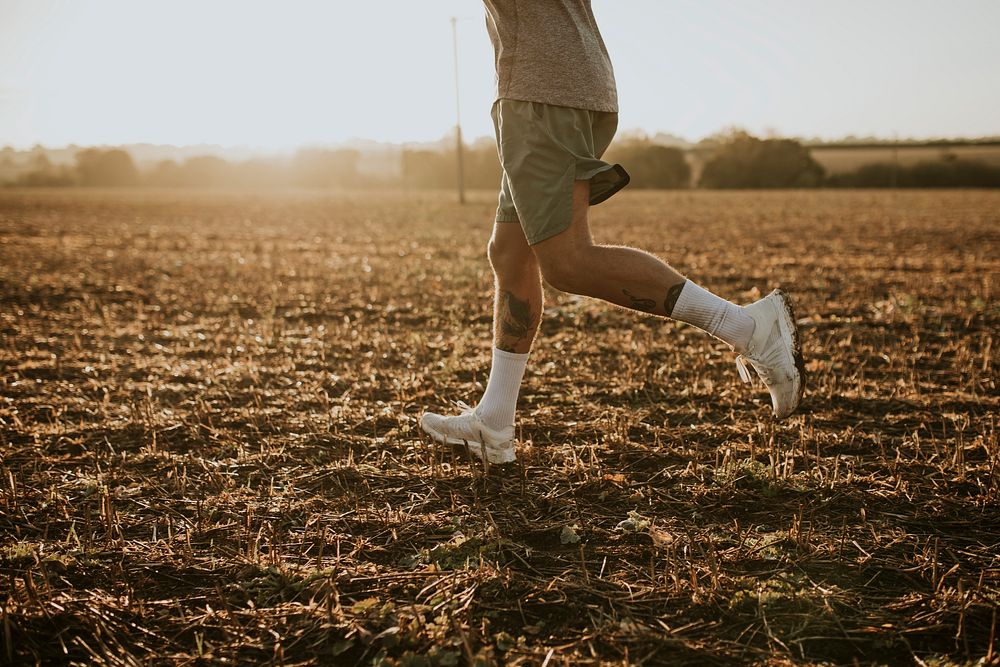 Active man in sportswear running in the countryside