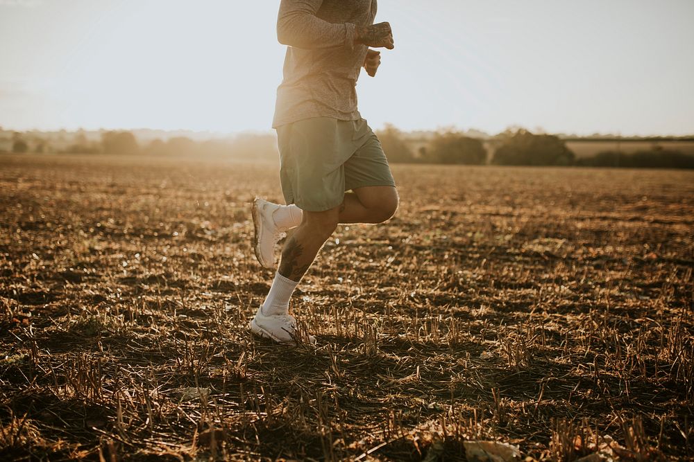 Active man in sportswear running in the countryside