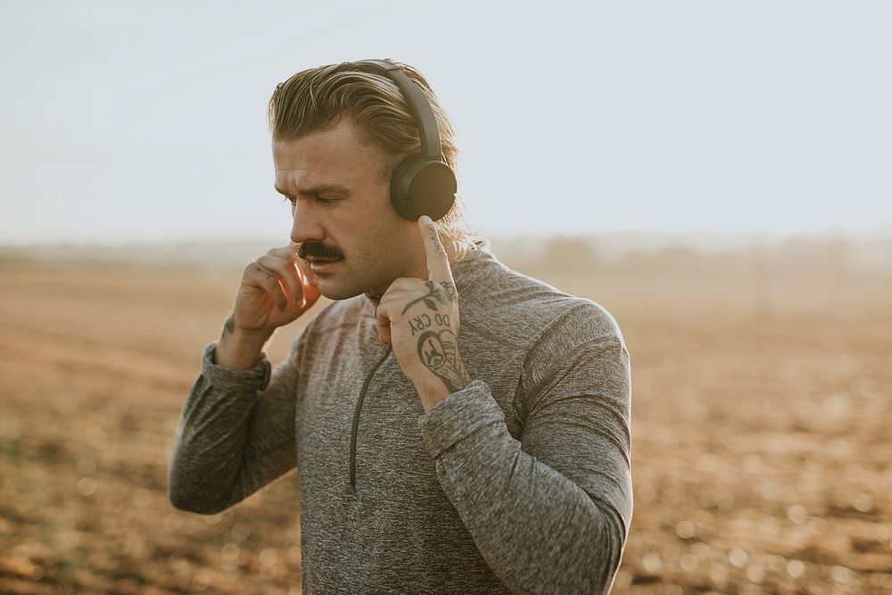 Cool man listening to music wearing wireless headphones