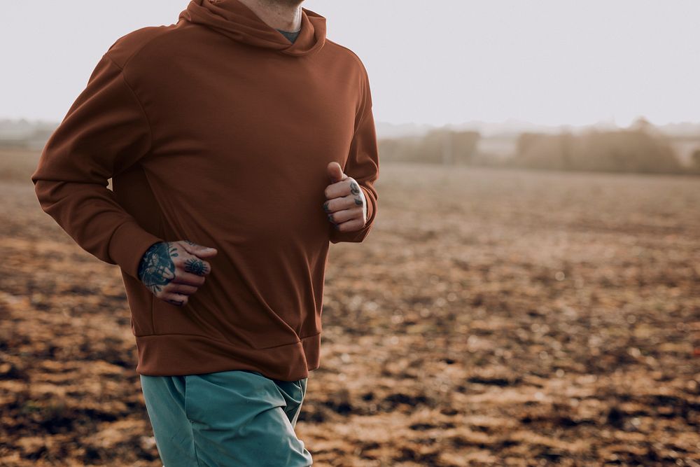 Man in stretchy hoodie in the countryside at sunset