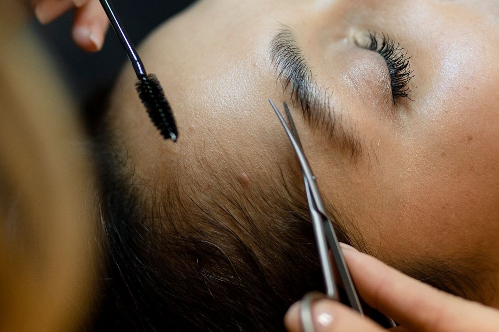 Customer getting eyebrow treatment at a beauty salon