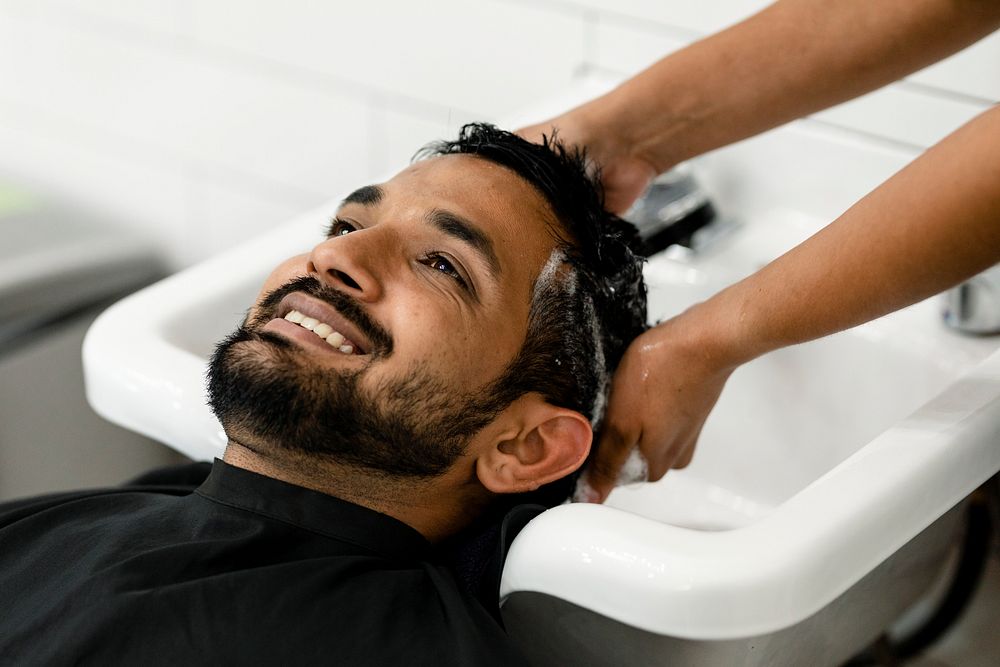 Man getting a hair wash at a barber shop 