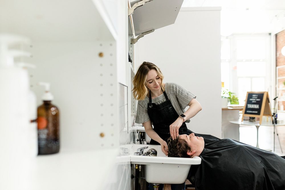 Hair stylist rinsing hair of the customer
