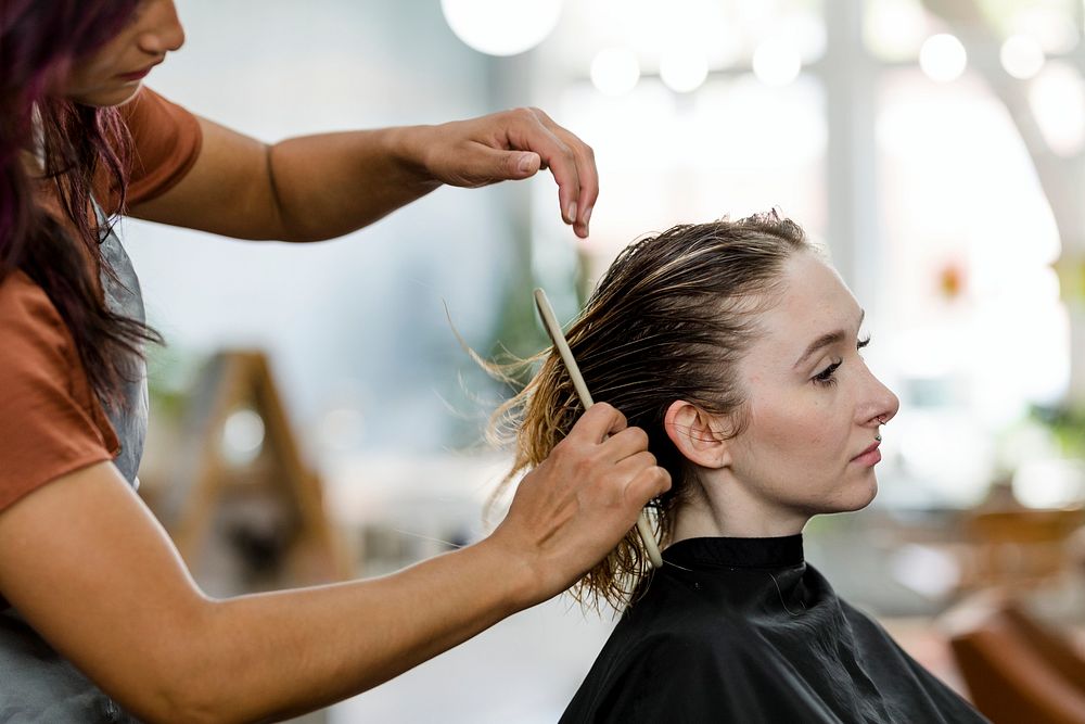 Hairstylist giving a haircut to a customer at a beauty salon 