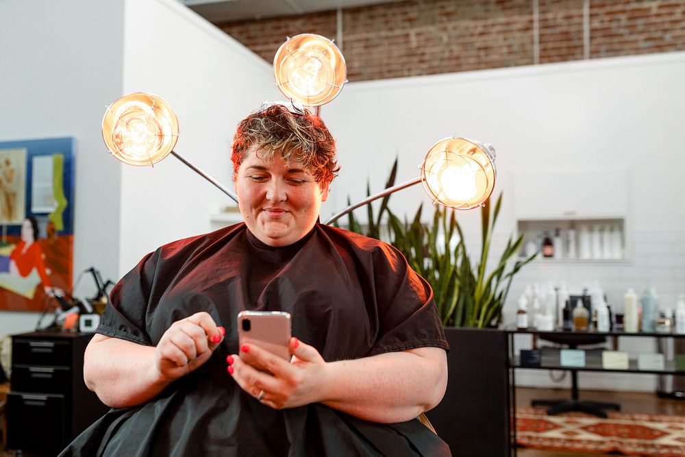 Woman browsing her phone at a salon