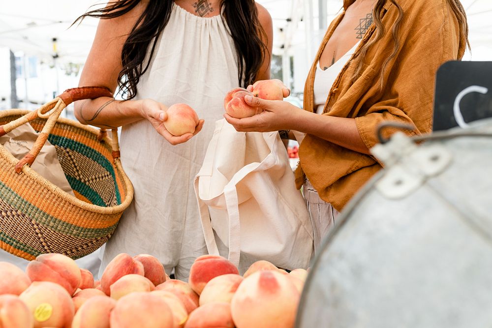 Women shopping for peach, buying at fruits fresh market
