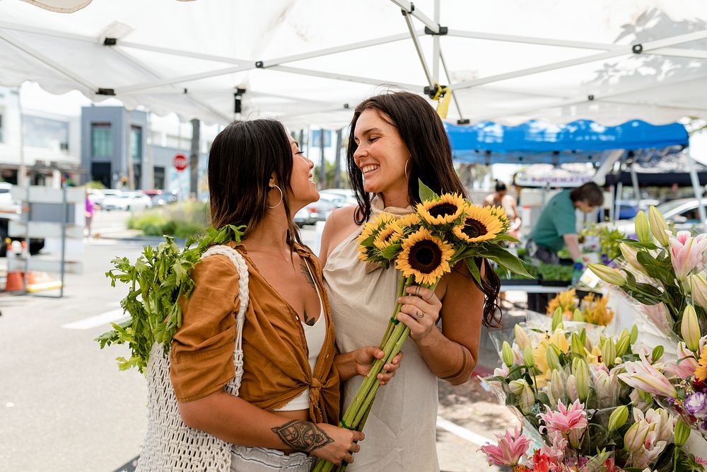 Lesbian couple flower shopping at a local market
