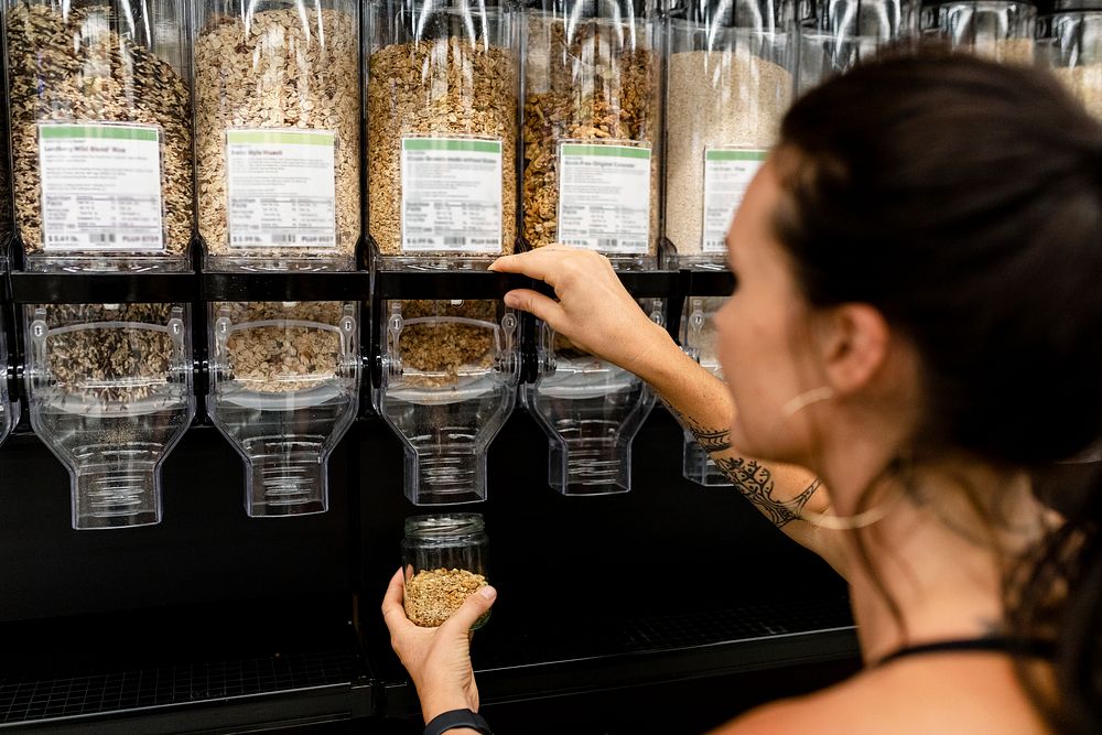 Zero waste shopping image, woman buying cereal with BYO jar