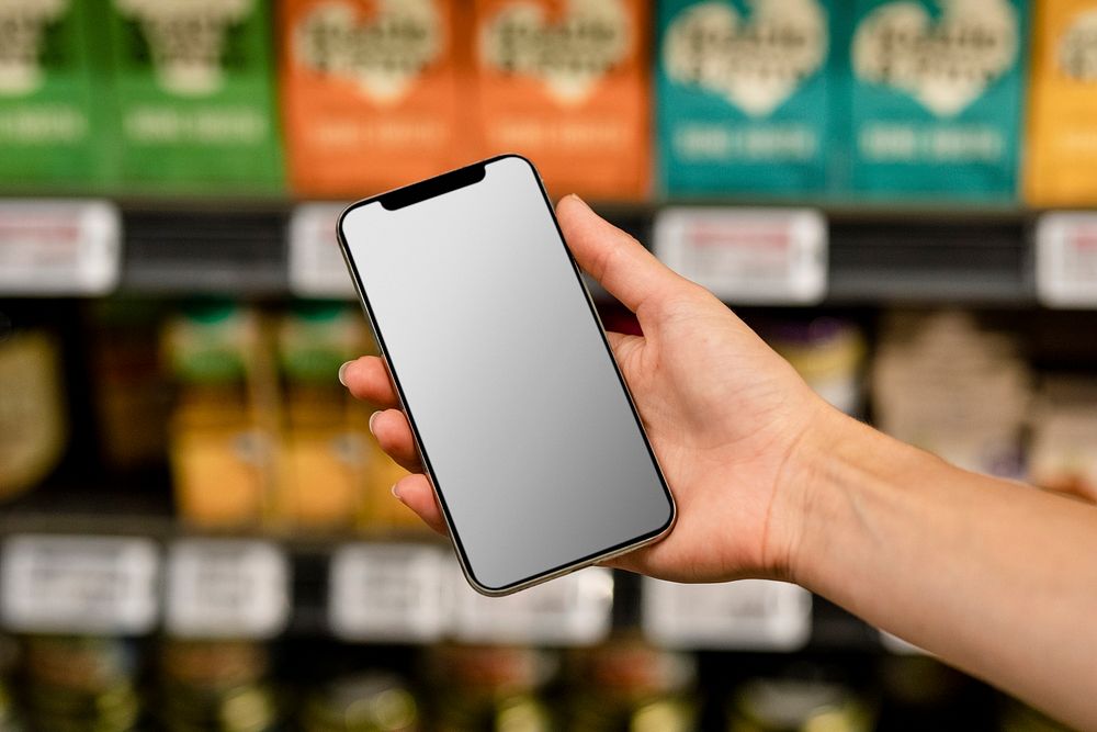 Phone screen mockup psd, held by a shopping woman doing grocery