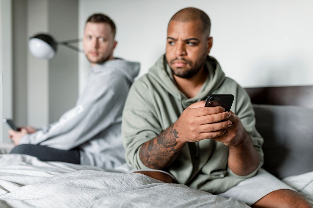 Angry gay couple image, sitting back-to-back after arguing