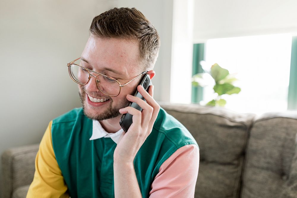 Man on phone call, sitting on a couch at home