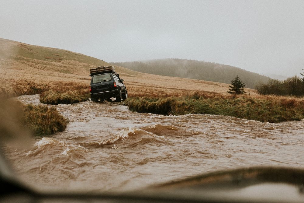 Off-roading car stuck in the water stream in nature