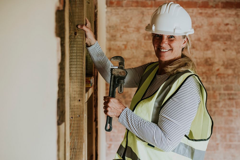 Woman worker remodeling home with a wrench