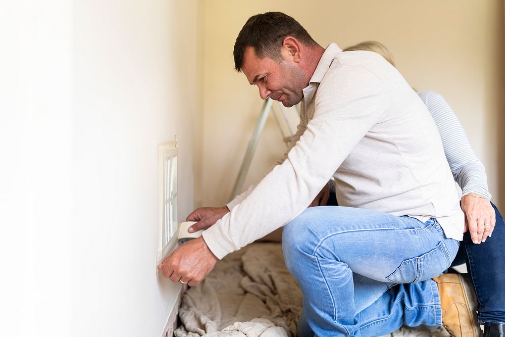 Husband fixing broken home ventilation