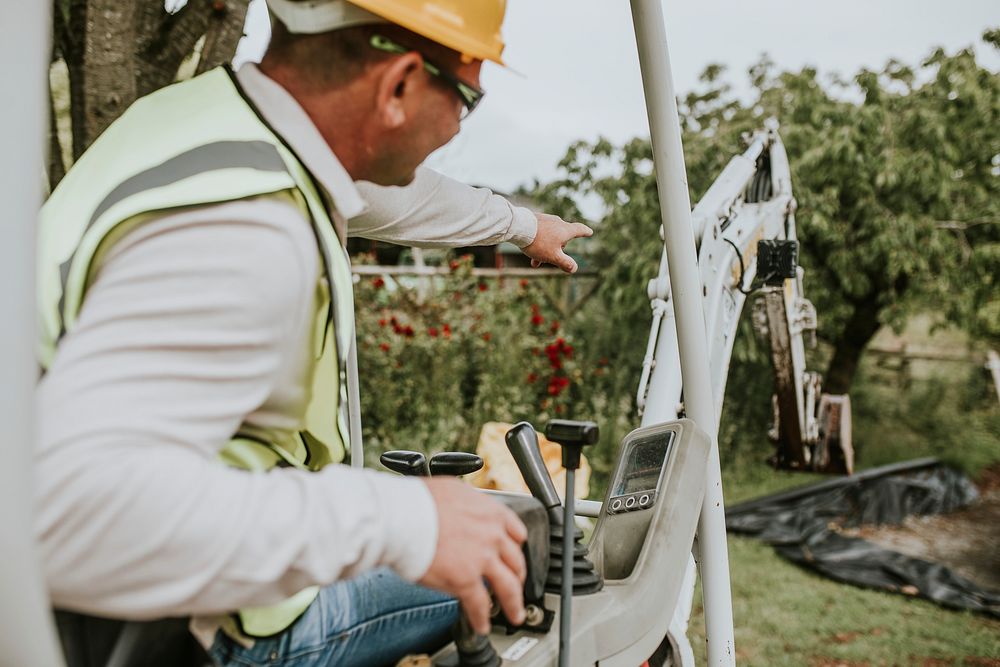 Contractor operating an excavator working on a home backyard 