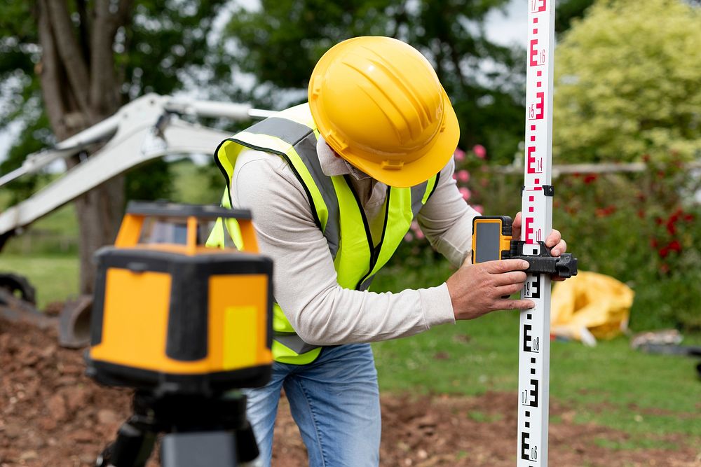 Contractor land surveying the backyard