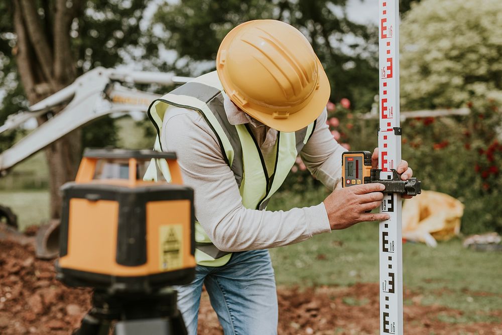 Civil engineer using a land surveying tool