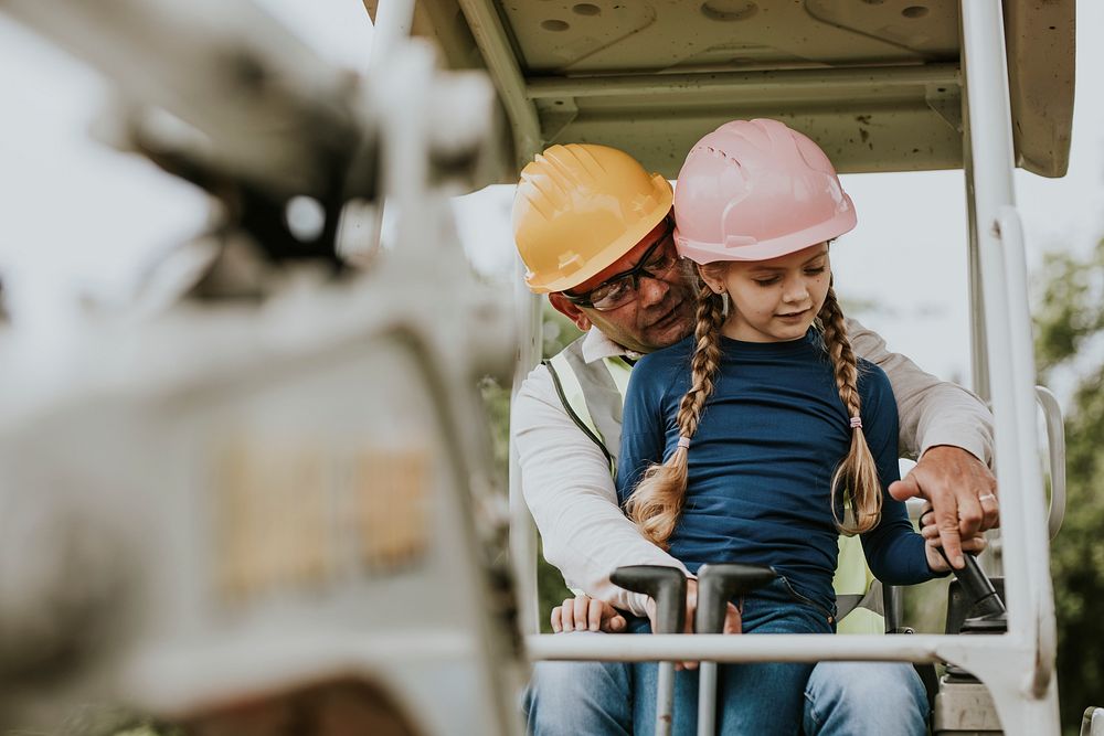 Father and daughter riding an excavator at a construction site