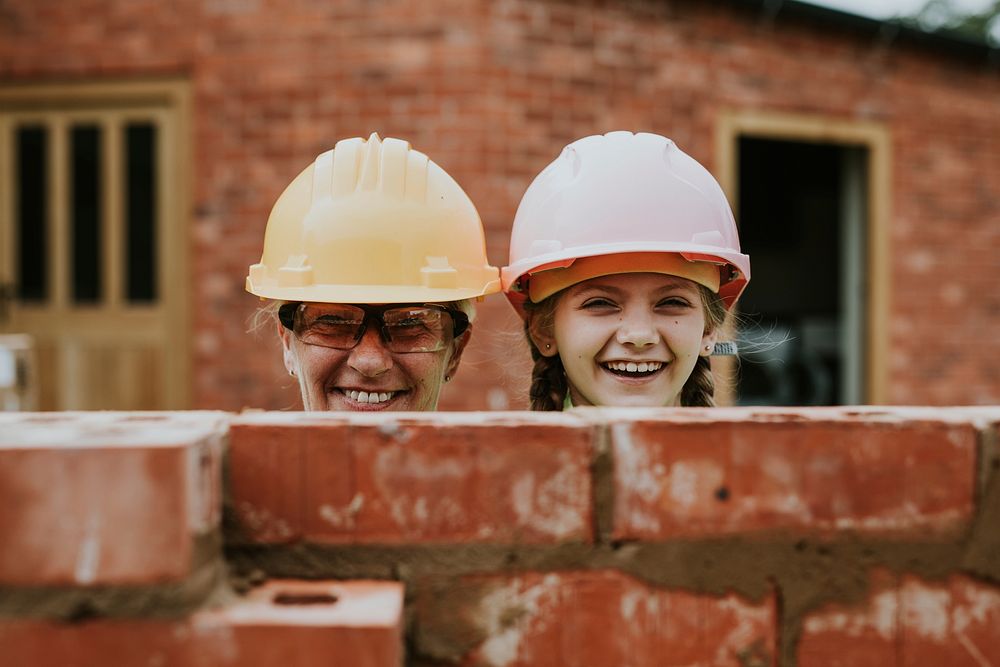 Playful mother and daughter bricklaying 