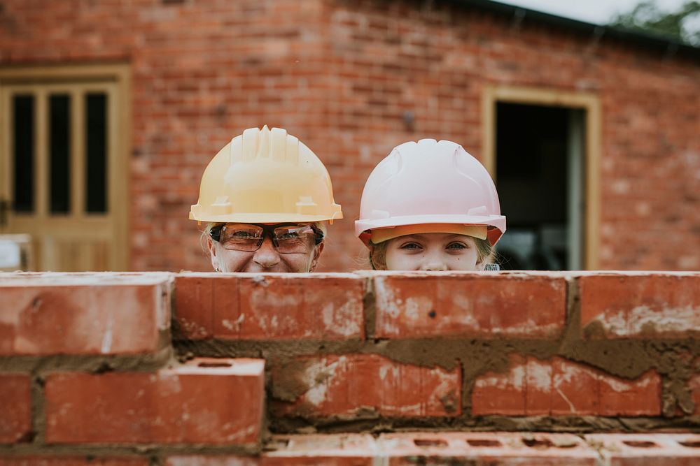 Playful mother and daughter bricklaying 