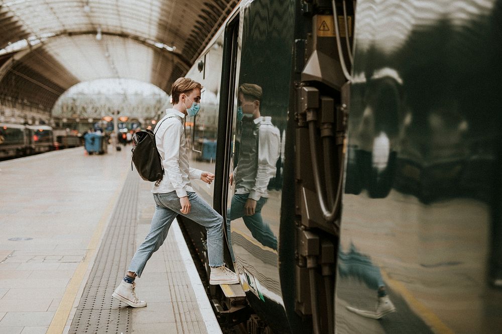 Man getting on a train from a platform 