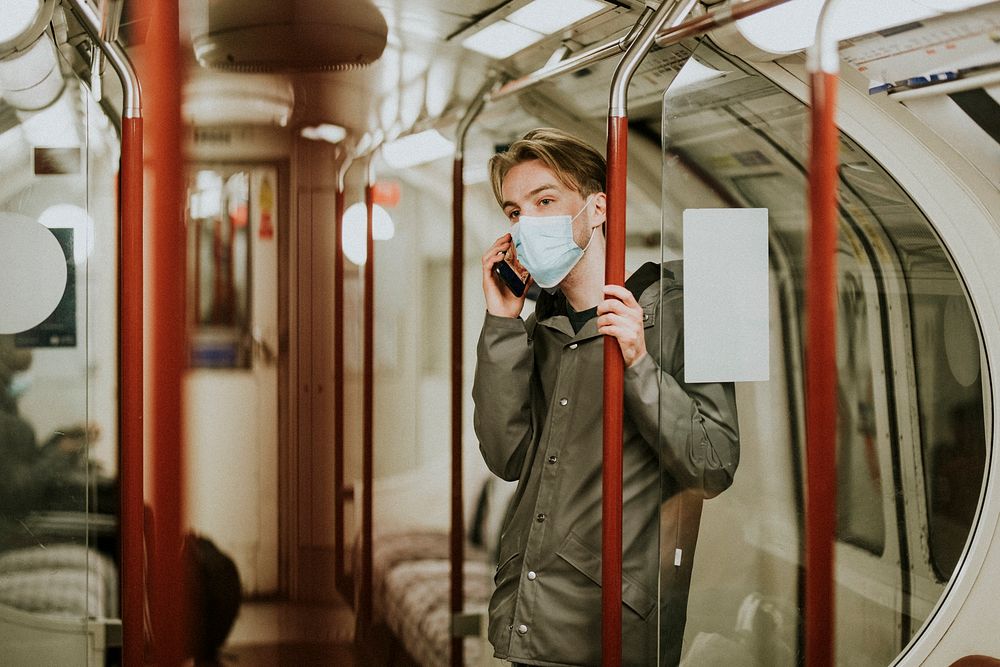 Man calling someone on a phone on a train in the new normal 