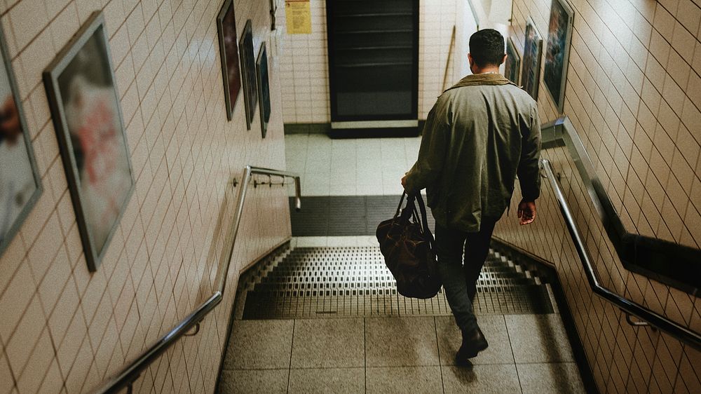 Man descending from the stairs towards the underground station 