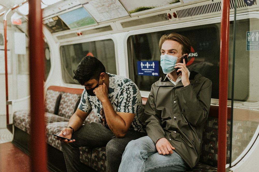Friends using a smartphone on a train in the new normal