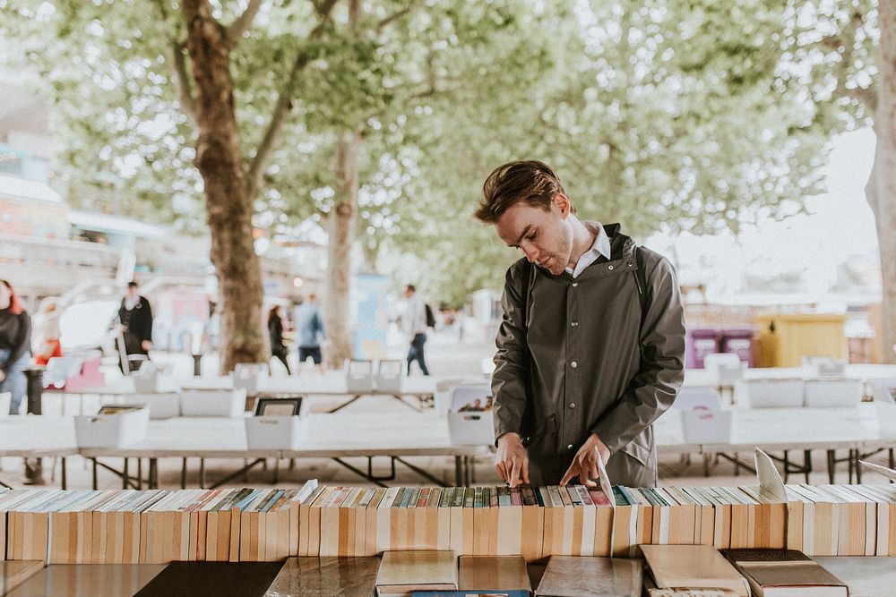 Man browsing secondhand books at street side used bookshop 