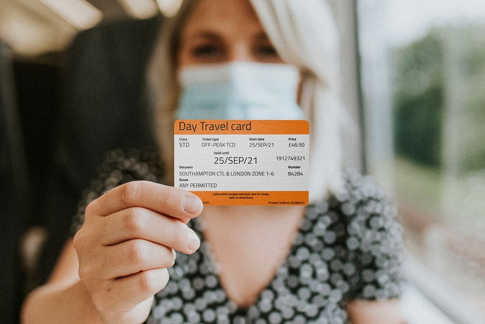Train ticket mockup psd daily pass being shown by a mask-wearing woman