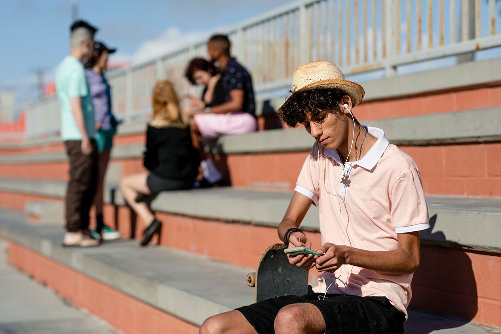 Teen boy listen to music, at a skatepark in Venice Beach, Los Angeles