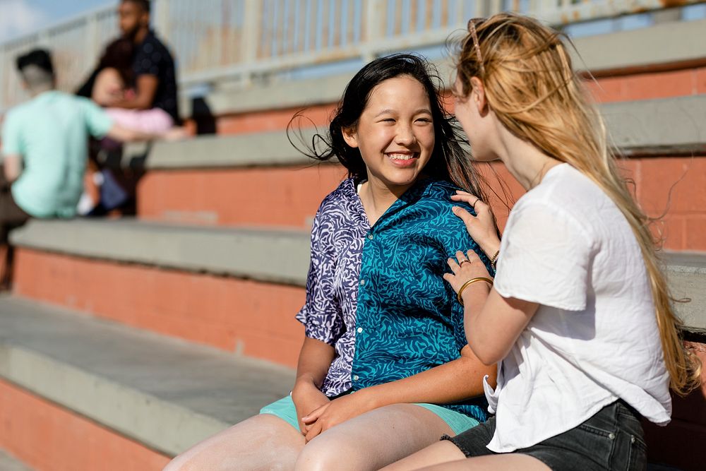 Teen comforting friend, sad girl talking about her problems