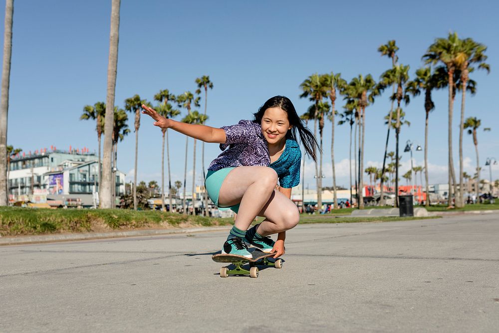 Happy girl skateboarding, fun outdoors sport activity
