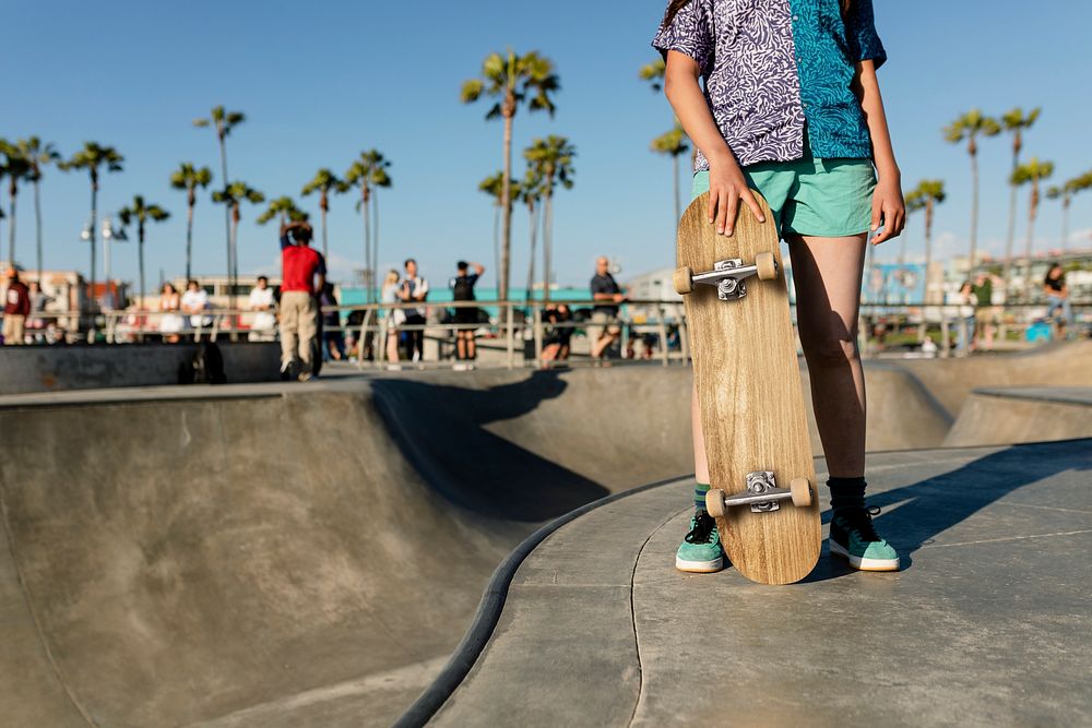 Teen girl with a skateboard, at a skatepark in Venice Beach, LA