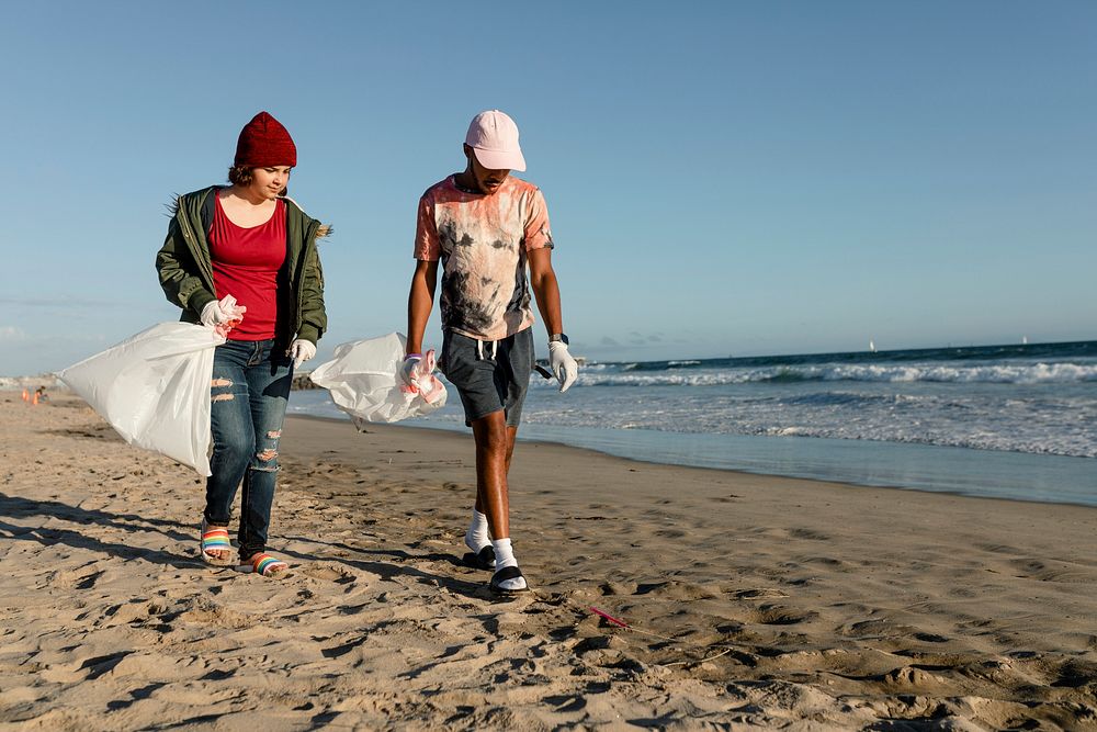 Teenagers cleaning beach, picking up trash volunteer work