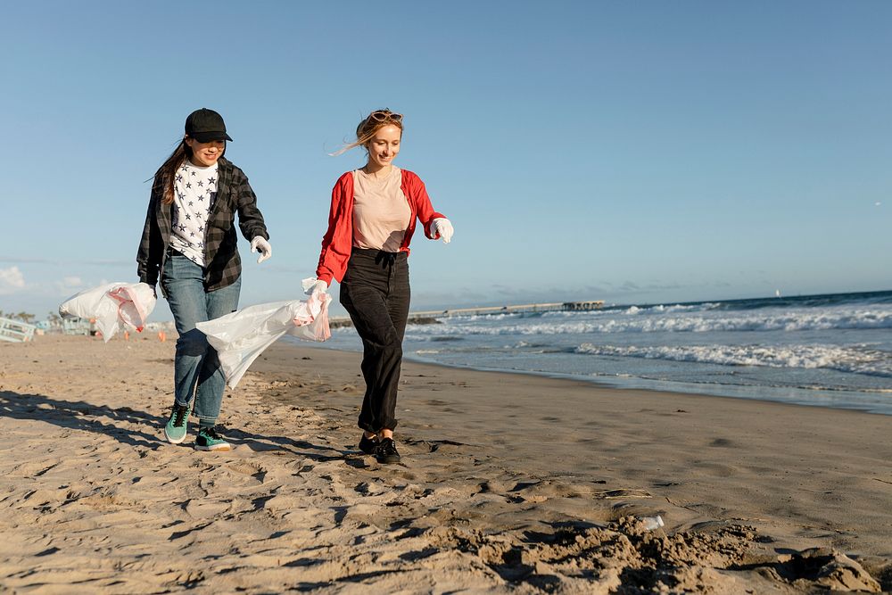 Trash pick up volunteering, teen friends at the beach