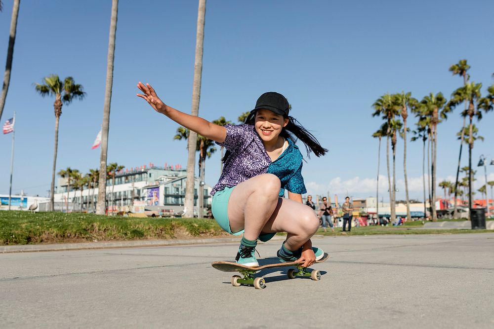 Happy girl skateboarding, fun outdoors sport activity