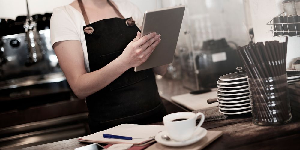 Woman cafe staff checking the tablet