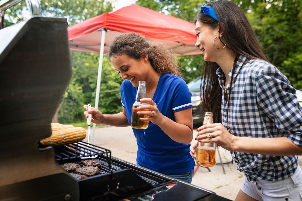 Girls grilling burgers at a tailgate party