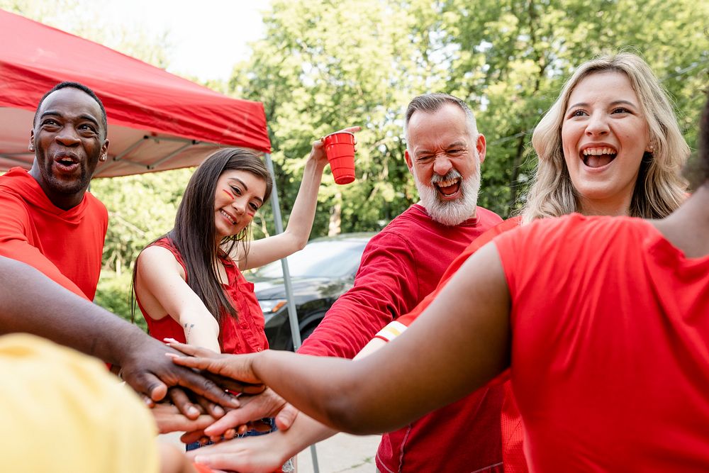 Sports fans in a huddle at a tailgate event